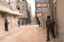 Forces loyal to Syria's President Bashar al-Assad patrol at Tal-al-Zrazir neighbourhood in Aleppo city