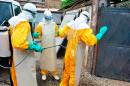 Medical staff clean their protection suits as part of the fight against the Ebola virus at the Donka hospital in Conakry on March 8, 2015