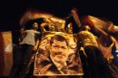 Members of the Muslim Brotherhood and supporters of deposed Egyptian President Mursi hold a banner with his picture as they gather at the Rabaa Adawiya square, in Cairo