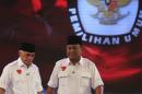 Indonesia's presidential candidate Prabowo Subianto and Hatta Rajasa walk during a televised debate with his opponent Joko "Jokowi" Widodo and Yusuf Kalla in Jakarta