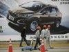 Workers walk past a poster of a car ahead of the Shanghai International Automobile Industry Exhibition (AUTO Shanghai) at the Shanghai International Exhibition Center in Shanghai, China Thursday, April 18, 2013. These should be good times for Chinese automakers as they prepare to show off their latest models at the Shanghai auto show. Their home market is the world's biggest and growing. But independent automakers such as Chery and Geely are being squeezed by bigger, richer global rivals including General Motors and Nissan that are creating low-priced models for local tastes. Domestic brands account for less than half of their own market.  (AP Photo/Eugene Hoshiko)
