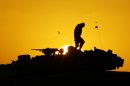 FILE - A U.S. soldier walks atop his armored vehicle at sunset as he prepares for a nighttime military exercise in the Kuwaiti desert south of the Iraqi border on Sunday, Dec. 22, 2002. Combat appears to have little or no influence on suicide rates among U.S. troops and veterans, according to a military study that challenges the conventional thinking about war's effects on the psyche published Tuesday, Aug. 6, 2013 in the Journal of the American Medical Association. (AP Photo/Anja Niedringhaus)