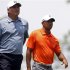 Fred Couples and Tiger Woods of the U.S. walk off the tee on the third hole during the first round of the Memorial Tournament in Dublin, Ohio