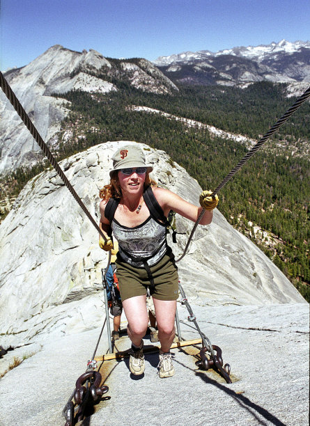 FILE - In this June 6, 2004 file photo, Thea Roberts, of Oakland, Calif., pulls herself up the cable route on the way to the summit of Half Dome, in Yosemite National Park. A long-awaited plan that officials say will make safer the iconic climb up Half Dome in Yosemite National Park has been approved. The hand-rail cables that some environmental groups argued don’t belong in a wilderness will stay, as will a lottery that will limit the number of hikers to roughly 400 a day. Over the past decade the route has been inundated with up to 1,200 nature lovers, causing traffic jams and a surge in calls for rescue. (AP Photo/Robert F. Bukaty)