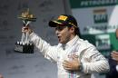 Williams driver Felipe Massa from Brazil, holds his trophy while celebrating after he finished third in the Formula One Brazilian Grand Prix at the Interlagos race track in Sao Paulo, Brazil, Sunday, Nov. 9, 2014. Germany's Nico Rosberg fended off a strong charge by Lewis Hamilton to win the race, closing in on his Mercedes teammate in the Formula One title race. (AP Photo/Felipe Dana)