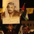 A Palestinian holds up a poster depicting late Palestinian leader Yasser Arafat during a ceremony marking the seventh anniversary of his death, in the West Bank city of Hebron