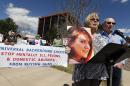 Lonnie Phillips, right, and his wife Sanday, who's daughter Jessica Ghawi was killed in the 2012 Aurora movie theatre massacre, speak at a rally against gun violence in front of Republican Congressman Mike Coffman's office, in Aurora, Colo., Wednesday April 23, 2014. The Phillips and other parents of Aurora theater shooting victims urged Coffman to support universal background checks in Congress. (AP Photo/Brennan Linsley)