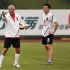 Coach Marcello Lippi gestures as Guangzhou Evergrande football club team member Qin Sheng stands next to him during a training session after a signing ceremony during a rainy day in Guangzhou