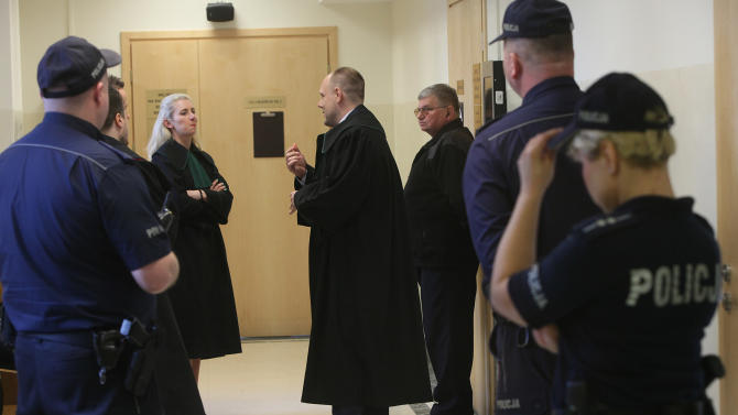 Unidentified attorneys representing Polish priest Wojciech Gil talk to  those representing victims in the Dominican Republic, background,  before the start of the priest’s trial on charges of abuse of minors, in the court corridor in Wolomin, near Warsaw, Poland,  Friday, March 20, 2015. The priest has been under arrest since February 2014 on charges of abusing six minors in the Caribbean island between 2009 and 2013 and two in Poland in 2000-2001. He could face up to 15 years in prison if convicted.  The media were barred from the courtroom and Gil was let in through the back door.(AP Photo/Czarek Sokolowski)