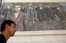 A man walks past a mosaic depicting Gavrilo Princip, the Bosnian-Serb nationalist who assassinated Archduke Franz Ferdinand in 1914, and other members of "Mlada Bosna" movement in the Bosnian town of Visegrad,140 kilometers east of Sarajevo, Saturday, June 28, 2014. Marking the centennial of the beginning of World War I in their own way, Bosnian Serbs in Visegrad on Saturday unveiled a mosaic of the man who ignited the war by assassinating the Austro-Hungarian crown prince on June 28, 1914. (AP Photo/Darko Vojinovic)