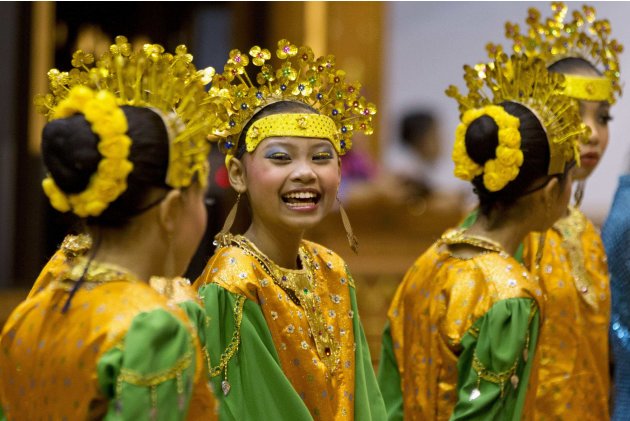 Girls in traditional costumes waits to greet foreign ministers before a cultural event at the ASEAN security conference in Bandar Seri Begawan