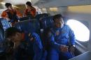 Crew members discuss after search operations for Malaysian Airlines flight MH370 were suspended, over the waters of South China Sea
