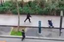 Masked gunman run towards a victim of their gun fire outside the French satirical newspaper Charlie Hebdo's office, in Paris, Wednesday, Jan. 7, 2015. Paris residents captured chilling video images of two masked gunmen shooting a police officer after an attack at a French satirical newspaper. In the video, the gunmen armed with assault rifles are seen running up to an injured police officer, who lies squirming on the ground. The police officer raises his hands up before one of the assailants shoots him in the head at a close range. (AP Photo) NO SALES