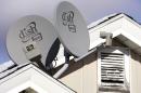 FILE - In this Nov. 10, 2008 file photo, Dish Network Corp. satellite dishes are attached to a home in Buffalo, N.Y. Dish Network and Disney have reached a landmark deal Tuesday, March 4, 2014, that envisions the day when Dish will offer a Netflix-like TV service to people who'd rather stream TV over the Internet than put a satellite receiver on their roof. (AP Photo/David Duprey, file)
