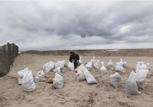 Martha Hiatt gathers sand bags at the Belle Harbor section of Rockaway beach in the Queens borough of New York