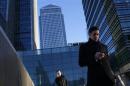 A worker looks at his phone at the Canary Wharf business district in London