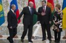 Belarusian President Alexander Lukashenko, second left, welcomes Russian President Vladimir Putin, left, Ukrainian President Petro Poroshenko, second right, and EU foreign policy chief Catherine Ashton, right, to their talks after after posing for a photo in Minsk, Belarus, Tuesday, Aug. 26, 2014. Leaders of Russia, Belarus, two other former Soviet republics as well as top EU officials are meeting in Minsk, Belarus, for a highly anticipated summit to discuss the crisis in Ukraine which has left more than 2,000 dead and displaced over 300,000 people. (AP Photo/Alexander Zemlianichenko)