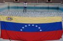 An opponent to Venenzuelan president Nicolas Maduro is seen next to a national flag before a rally in Caracas