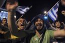 Greece soccer supporters celebrate their team's win in a World Cup soccer match in front of the city's landmark of White Tower, in the northern Greek port of Thessaloniki, on Wednesday, June 25, 2014. Greece won Ivory Coast 2-1 to advance to the round of 16 for the first time in their World Cup history. (AP Photo/Nikolas Giakoumidis)