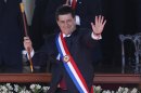 Paraguay's New President Horacio Cartes waves holding the presidential baton and wearing the presidential sash during his swearing-in ceremony at Palacio de Lopez presidential palace in Asuncion, Paraguay, Thursday, Aug. 15, 2013. (AP Photo/Jorge Saenz)