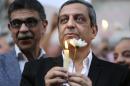In this Tuesday, May 24, 2016 picture, Yahia Kalash, the head of journalists' union, holds a candle during a candlelight vigil for the victims of EgyptAir flight 804 in front of the Journalists' Syndicate in Cairo, Egypt. The head of Egypt's journalists union and two of its board members have been questioned by prosecutors over allegations that they harbored journalists wanted by authorities and spreading false news, one of the three and their lawyer said on Monday. (AP Photo/Amr Nabil)