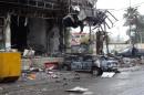 A picture taken on December 5, 2013 shows damage and a burnt vehicle after a mall in the northern Iraqi city of Kirkuk was stormed by security forces to end an hours-long siege