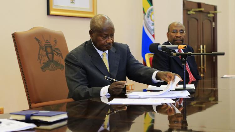 Uganda President Yoweri Museveni signs an anti-homosexual bill into law at the state house in Entebbe