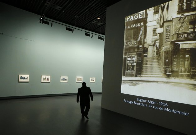 A man walks by a Eugene Atget photography display as part of the retrospective for Edward Hopper, one of the great American 20th century artists at Paris’ Grand Palais Museum, in Paris, Monday, Oct. 8, 2012. This major Hopper retrospective reveals that the 20th century painter known for his rendering of American life, also drew inspiration from France, and includes some 128 Hopper works, such as the masterpieces “Nighthawks” and “Soir Bleu”.(AP Photo/Francois Mori)