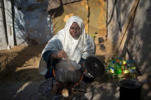 A Palestinian woman cooks her food on fire wood in …