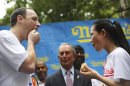 New York City Mayor Michael Bloomberg, center, watches and Joey Chestnut, left, and Sonya Thomas face off while eating a hot dog after the official weigh-in for the Nathan's Fourth of July hot dog eating contest, Wednesday, July 3, 2013 at City Hall park in New York. (AP Photo/Mary Altaffer)