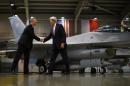 US Secretary of State John Kerry (R) shakes hands with Poland's Defence Minister Tomasz Siemoniak in front of an F-16 aircraft at the Lask Air Force Base, on November 5, 2013
