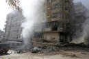 A man tries to extinguish a fire after a Syrian Air force air strike in Ain Tarma neighbourhood of Damascus