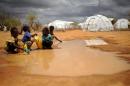 Boys fetch water on October 16, 2011 from a puddle in the sprawling Dadaab refugee complex in Kenya