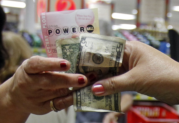 A customer buys three Powerball tickets at a local supermarket in Hialeah, Fla.,Tuesday, Nov. 27, 2012. There has been no Powerball winner since Oct. 6, and the jackpot already has reached a record level for the game. Already over $500 million, it is the second-highest jackpot in lottery history, behind only the $656 million Mega Millions prize in March. (AP Photo/Alan Diaz)