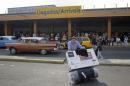 A passenger pushes a luggage cart after arriving on a charter flight from Tampa at the airport in Havana