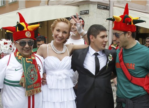 Portuguese soccer fans pose for photographs with newlyweds in central Lviv