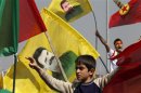 Demonstrators hold Kurdish flags and flags with portraits of jailed Kurdistan Workers Party leader Ocalan during a gathering to celebrate Newroz in the southeastern Turkish city of Diyarbakir