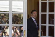 <p>               Photographers are seen reflected in a glass door as Spain's Prime Minister Mariano Rajoy steps out to greet   European Council President Herman van Rompuy, unseen at the Moncloa Palace in Madrid Tuesday Aug. 28, 2012.  Rajoy and van Rompuy met for talks on the economic crisis and Spain's battle to avert having to seek a sovereign bailout. (AP Photo/Paul White)
