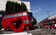 A London bus that has been transformed into a robotic sculpture by Czech artist David Cerny is assembled in front of the Czech Olympic headquarters in London July 22, 2012. The bus, which Cerny hopes could become an unofficial mascot of the London 2012 Olympic Games, does push-ups with the help of an engine powering a pair of robotic arms and the motion is accompanied by a recording of sounds evoking tough physical effort. It will be parked outside the Czech Olympic headquarters in London for the duration of the Games. REUTERS/Marika Kochiashvili