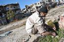 A Syrian man looks for herbs to eat with his family in the heavily damaged neighbourhood of Juret al-Shiyah, in the central Syrian city of Homs on February 1, 2014
