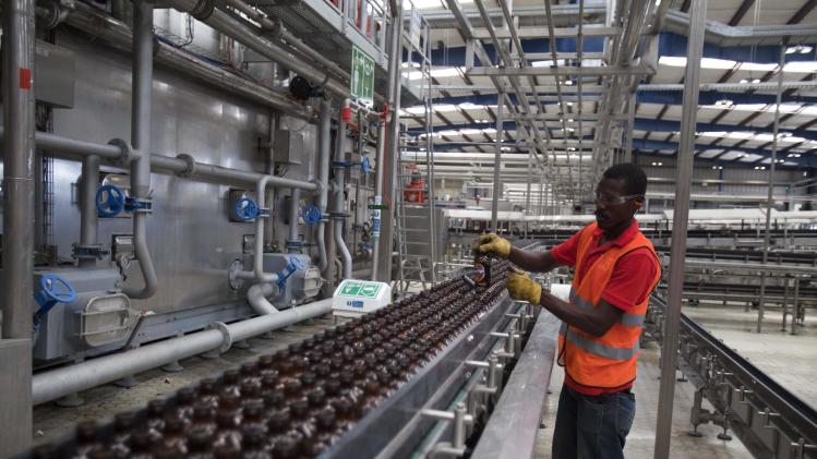 A worker cleans empty bottles of Prestige Beer at the Heineken/Brana Brewery S.A. in Port-au-Prince, Haiti, Friday April 4, 2014. Heineken NV says it is investing $100 million in the struggling Caribbean nation of Haiti. ( AP Photo/Dieu Nalio Chery)