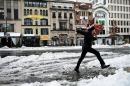 A man jumps over a puddle on Connecticut Avenue in Washington, February 13, 2014