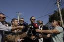 Ilias Kasidiaris, center, lawmaker of the extreme right party Golden Dawn speaks to reporters in front of the party's office in northern Athens, Saturday, Nov. 2, 2013. Police looking for clues to the Friday evening murder of two members of the far-right Golden Dawn party and the grievous injury to a third say the gun used in the attack has not been used in previous terrorist attacks. (AP Photo/Kostas Tsironis)