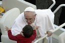 Pope Francis kisses a child in St. Peter's Square at the Vatican, Tuesday, March 19, 2013. Pope Francis officially began his ministry as the 266th pope on Tuesday in an installation Mass simplified to suit his style, but still grand enough to draw princes, presidents, rabbis, muftis and thousands of ordinary people to St. Peter's Square to witness the inauguration of the first pope from the New World. (AP Photo/Riccardo De Luca)
