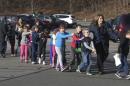 FILE - In this Dec. 14, 2012 file photo provided by the Newtown Bee, Connecticut State Police lead a line of children from the Sandy Hook Elementary School in Newtown, Conn., where gunman Adam Lanza opened fire, killing 26 people, including 20 children. (AP Photo/Newtown Bee, Shannon Hicks, File) MANDATORY CREDIT: NEWTOWN BEE, SHANNON HICKS