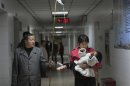 File picture of a man using a stick to hold up a drip for his granddaughter at a hospital in Hefei
