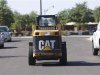 A worker drives a Caterpillar tractor near a construction site in Gilbert