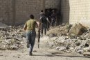 Free Syrian Army fighters carry their weapons as their move towards their positions in the al-Ziyabiya area in Damascus