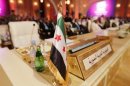 La bandiera dell'opposizione siriana a segnare il posto del delegato siriano all'apertuta del summit della Lega araba a Doha