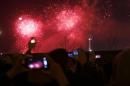 Visitors take pictures and videos as fireworks explode over Oriental Pearl Tower as part of a New Year countdown celebration on the Bund in Shanghai January 1, 2014. REUTERS/Aly Song